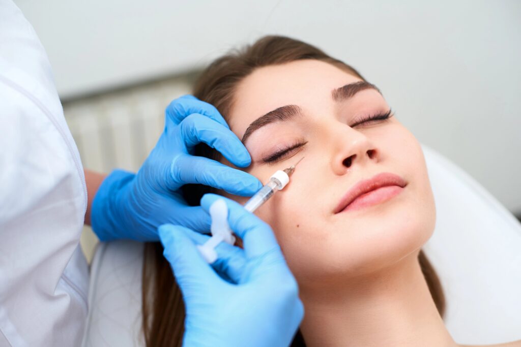 Young woman receiving under-eye injection from professional