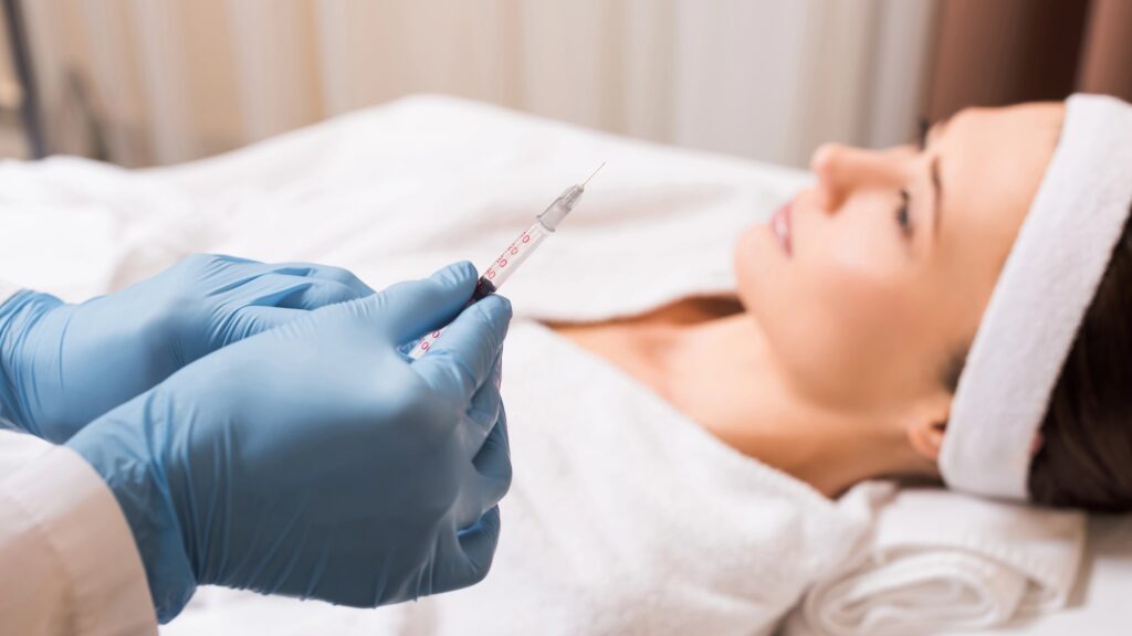 Medical professional holding syringe, female patient in background