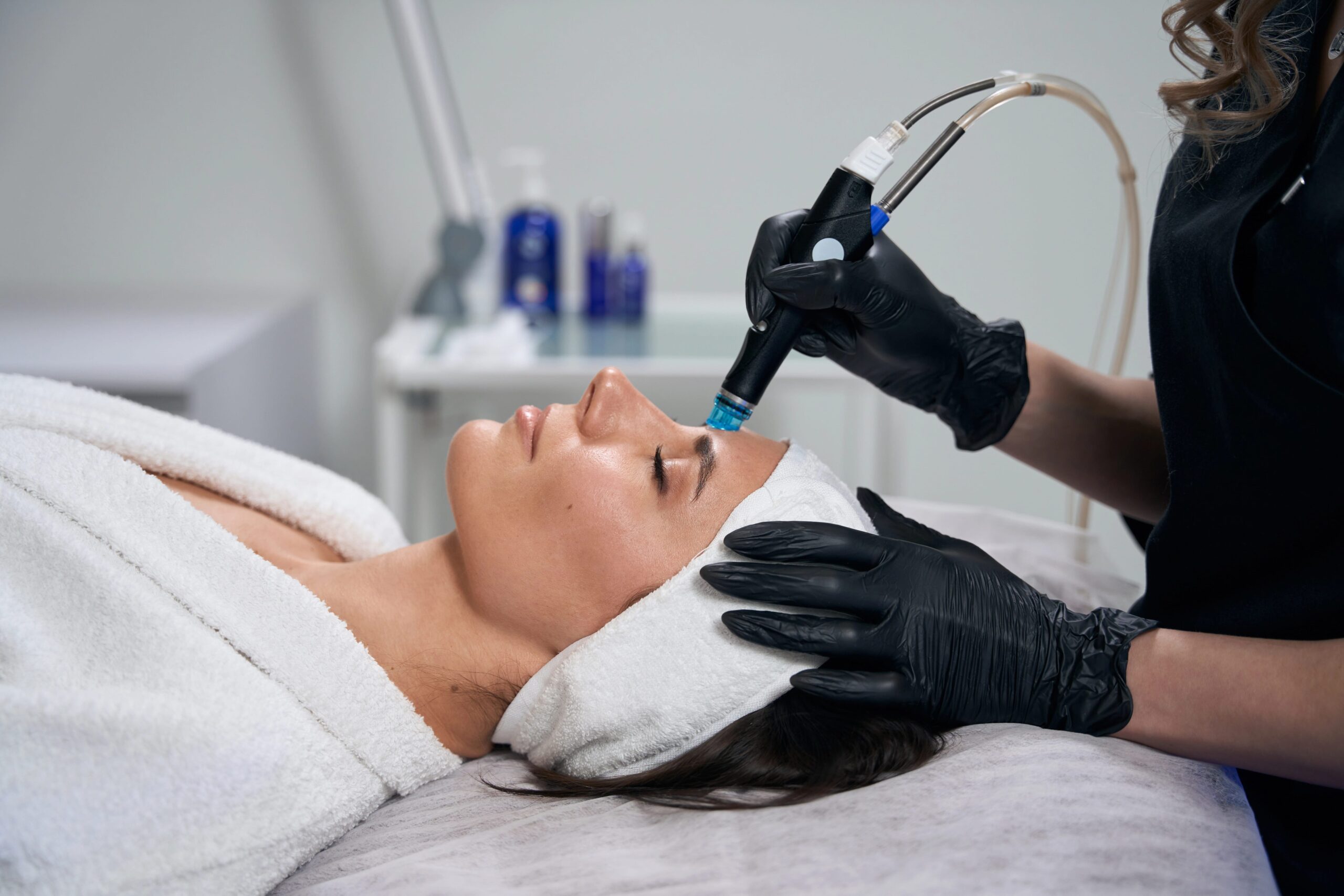 Woman receiving hydrafacial, silhouette